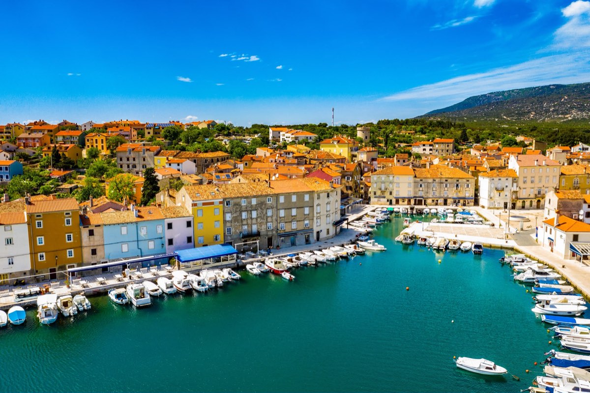 Porto della città di Cherso con pescherecci e facciate pastello