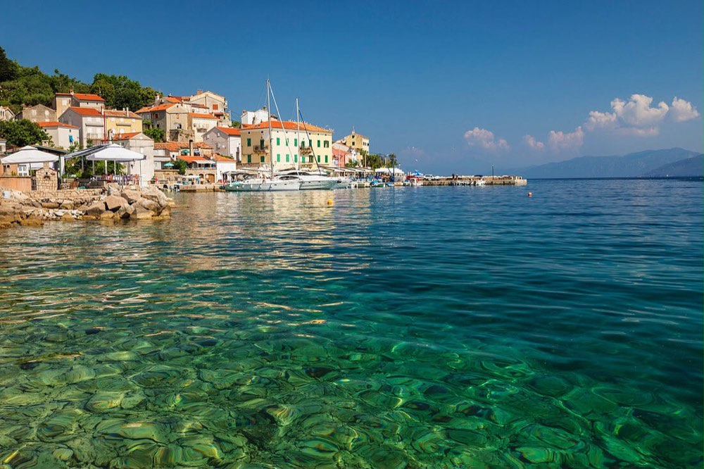 Spiaggia di ghiaia e mare limpido nella baia di Valun, Cherso