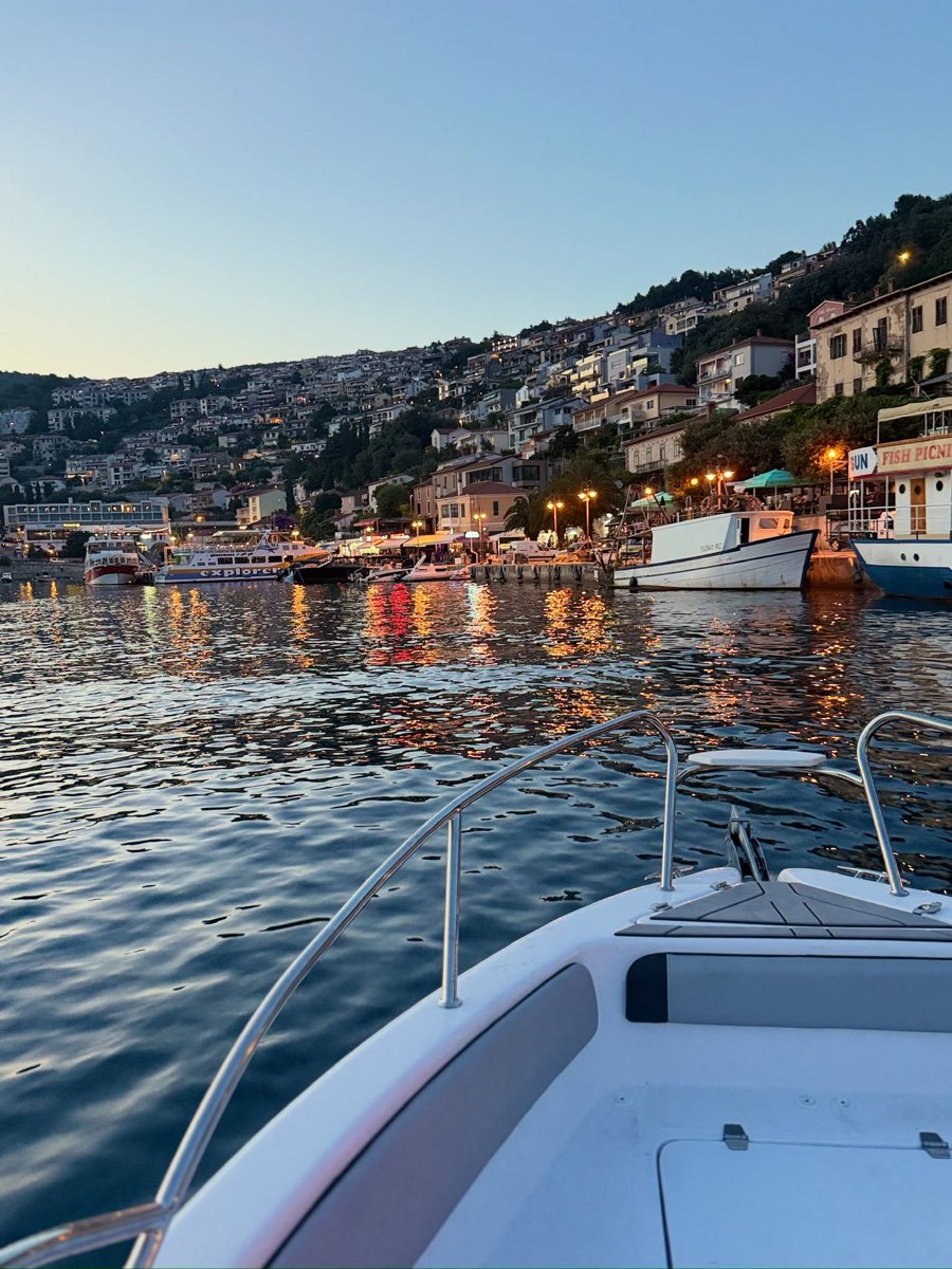 Vista dalla barca al rientro serale nel porto illuminato di Rabac